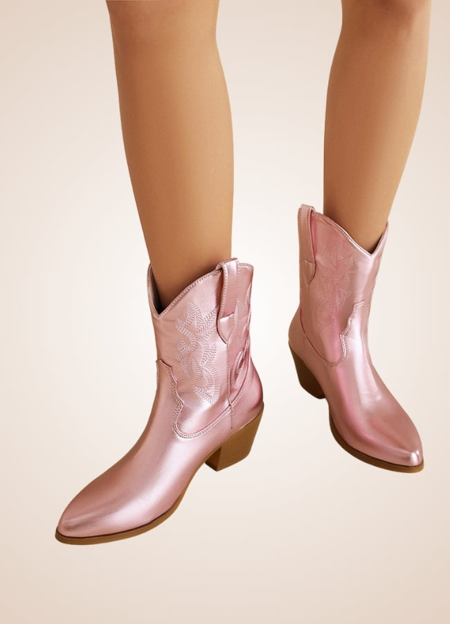 Shiny pink cowboy cowgirl boots with embroidered details, featuring a pointed toe and mid-heel design. Stylish and trendy footwear for women.