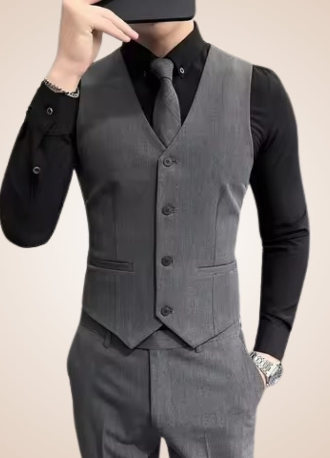 Gray suit vest worn over a black shirt with a beige background